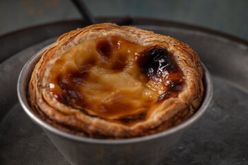 Golden-brown Portuguese custard tart with a flaky crust