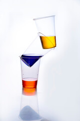 balancing plastic glasses with colorful liquid