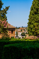 A Picturesque View of Granada Framed by Alhambra’s Verdant Gardens and Historic Architecture, Overlooking the Whitewashed Houses and Cypress Trees