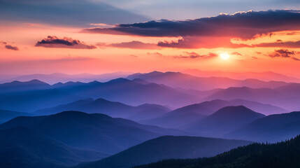 Obraz premium Colorful sunset over rolling mountain ridges with misty blue and pink hues in the sky creating a dreamlike and peaceful atmosphere 