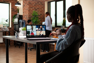 Black businesswoman speaking with potential investors during a virtual meeting on her laptop. Female manager using digital device to conduct an online discussion with her employees on video call.
