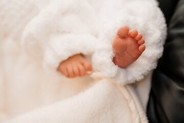 Obraz premium A Cozy Moment: Newborn Feet Peeking from Soft Blanket