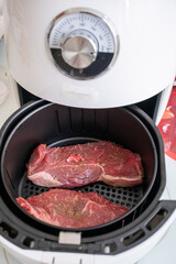 Close up of beef steak being cooked in white airfryer