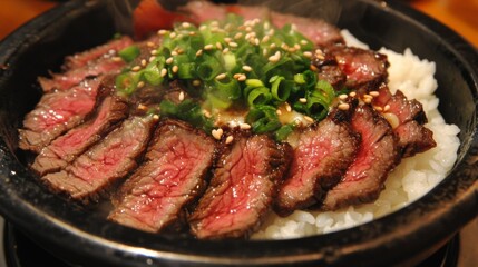A close-up of tender slices of beef served over a bowl of steaming white rice, topped with a savory sauce and garnished with fresh green onions and sesame seeds