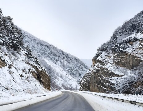 Snow-Covered Mountain Roadway and Cliffs