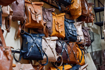 Different leather bags sewn artisanally displayed in souvenir shop in Marrakech.