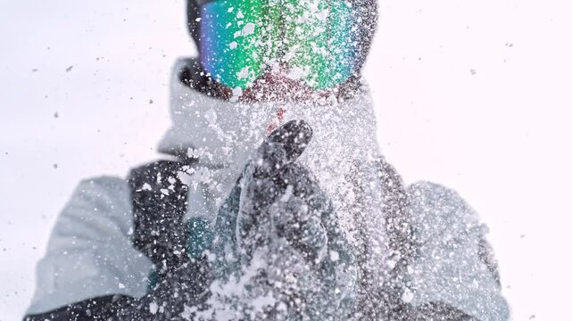 Closeup of Snowboarder Clapping his Hands with Powder Snow. Super Slow Motion Footage, Filmed on High Speed Cinema Camera, 1000 fps. Speed Ramp Effect.