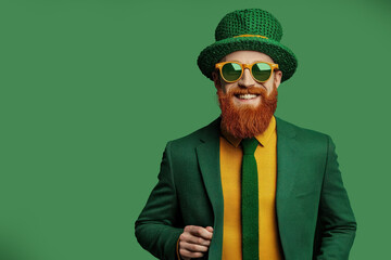 Man hat green traditional Irish attire holding Happy St. Patrick's Day sign, copy space. St. Patrick's Day celebration and festive concept