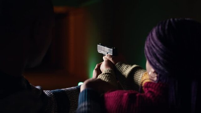 Shooting gallery worker teaching student how to hold pistol, close up. Firing range specialist providing guide to woman learning how to achieve high level of proficiency with firearms, camera B