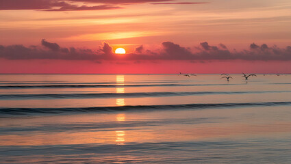 A tranquil sunset casting golden and pink hues over calm ocean waves