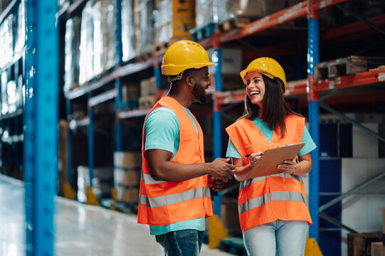 Warehouse workers discussing logistics and inventory management with clipboards