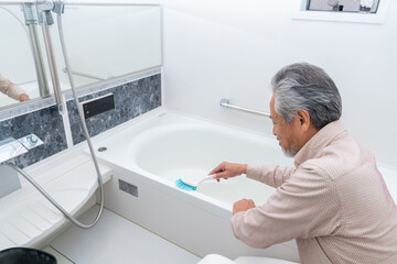 お風呂を掃除するシニア男性