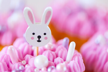 Easter Bunny Muffins with pink and purple cream.Easter cupcakes with white rabbits topiary with pink cream. Catholic and Orthodox holidays.baked goods for spring holidays.Cute Bunny Decoration on Cake