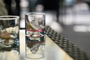 empty glasses on a bar table with ice cubes