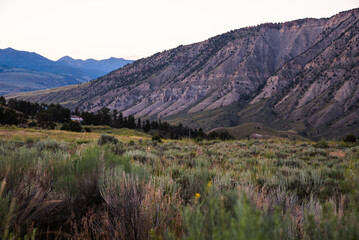 Mountain hills and green valley bathed in glow after sunset