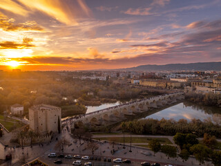 Aerial view of Cordoba Spain with colorful sunset sky over the Roman bridge, medieval downtown, cathedral