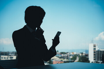 シルエットのビジネスマン（スマホ詐欺・詐欺師・詐欺・離職・離職率）
