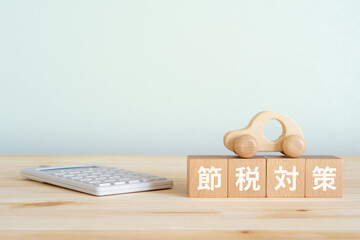 節税対策と書かれたブロック、電卓、車のおもちゃ