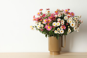 Vase with beautiful flowers on wooden table, space for text