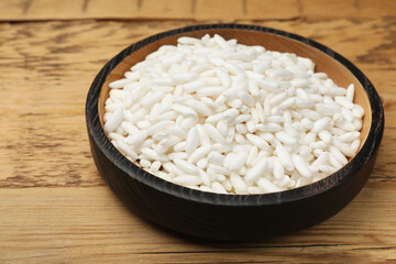 Puffed rice in bowl on wooden table, closeup