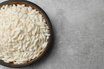 Puffed rice in bowl on light grey table, top view. Space for text