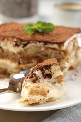 Piece of tasty tiramisu on table, closeup