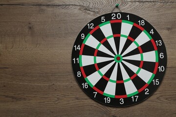 One dart board hanging on wooden background. Space for text