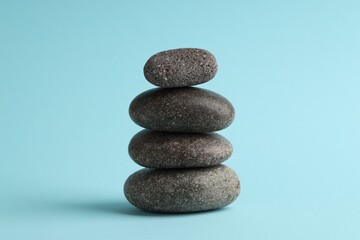 Stack of rocks on light blue background. Harmony and life balance