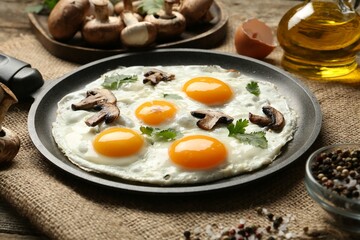 Tasty fried eggs with mushrooms and parsley served on wooden table, closeup
