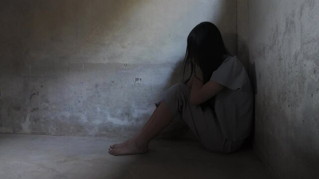 Sad young girl sitting in the dark room, Domestic violence, family problems, Stress, violence, The concept of depression and suicide.