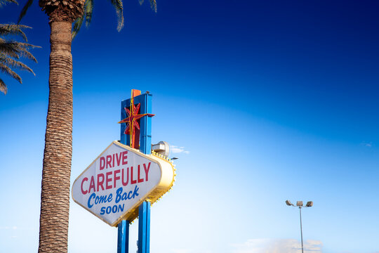 The back of the 'Welcome to Fabulous Las Vegas' sign reads “Drive Carefully, Come Back Soon,” bidding a friendly farewell to departing visitors under sunny skies.