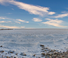 Frozen lake shore under a bright winter sky.  Peaceful, icy landscape.