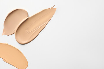 Samples of foundations on white background, top view