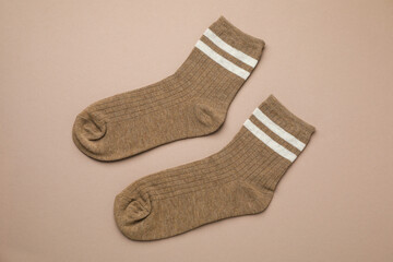 Pair of soft comfortable socks on brown background, top view