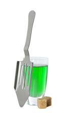 Absinthe in shot glass, brown sugar cubes and slotted spoon isolated on white