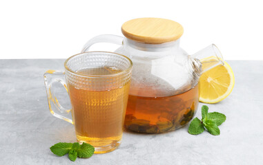 Aromatic mint tea, fresh leaves and lemon on light gray table against white background