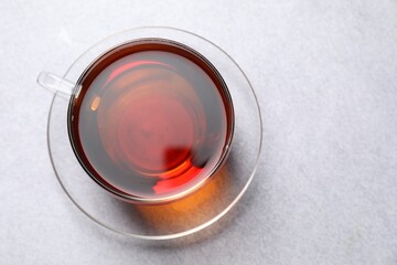 Aromatic black tea in cup on light table, top view. Space for text