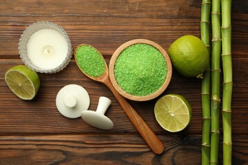Spa composition with fresh limes, sea salt and bamboo stems on wooden table, flat lay