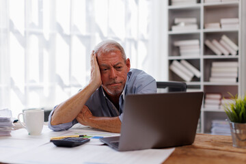 Sad gray-haired architect Senior man working in modern office at computer, businessman thinking about failures,Sad, unhappy, Worried, Depression, or employee life stress concept