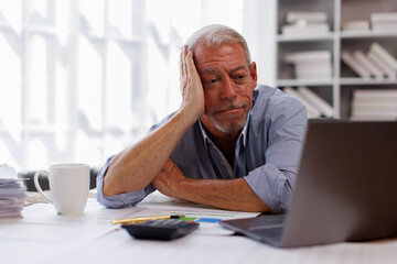 Sad gray-haired architect Senior man working in modern office at computer, businessman thinking about failures,Sad, unhappy, Worried, Depression, or employee life stress concept