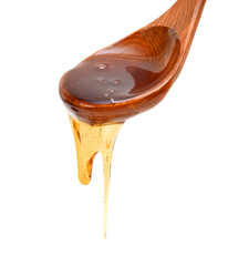 Honey dripping from a wooden honey dipper isolated on white background