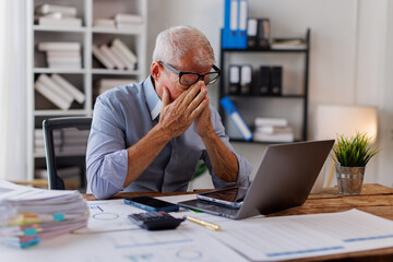 Sad gray-haired architect Senior man working in modern office at computer, businessman thinking...