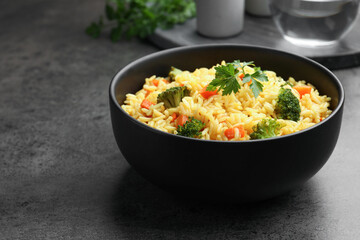 Tasty rice with vegetables on grey table, closeup. Space for text