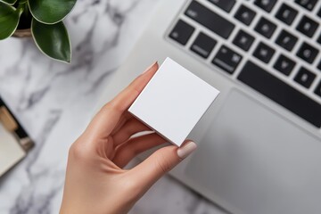 Obraz premium A woman is holding a white box in front of a laptop