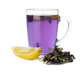 Delicious butterfly pea flower tea in glass mug, lemon and dry petals isolated on white