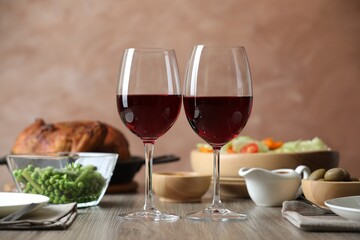 Red wine and delicious dinner served on wooden table
