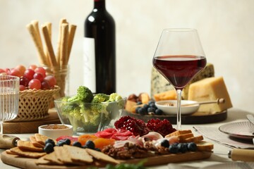 Red wine and different snacks served on table