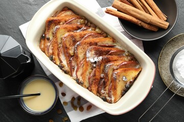 Flat lay composition with freshly baked bread pudding on dark textured table