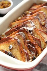 Freshly baked bread pudding in baking dish on table, closeup