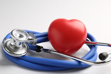 Cardiology. Stethoscope and red decorative heart on white background, closeup